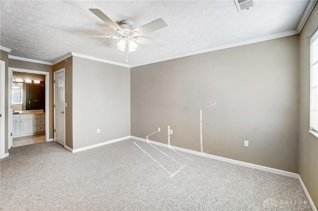 carpeted empty room with ceiling fan, ornamental molding, and a textured ceiling