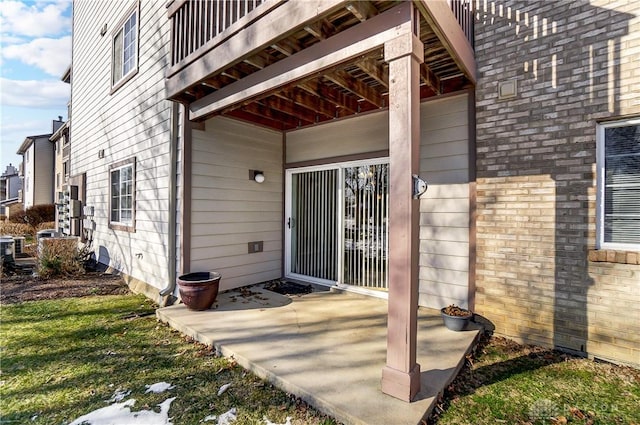 property entrance with a patio and a lawn