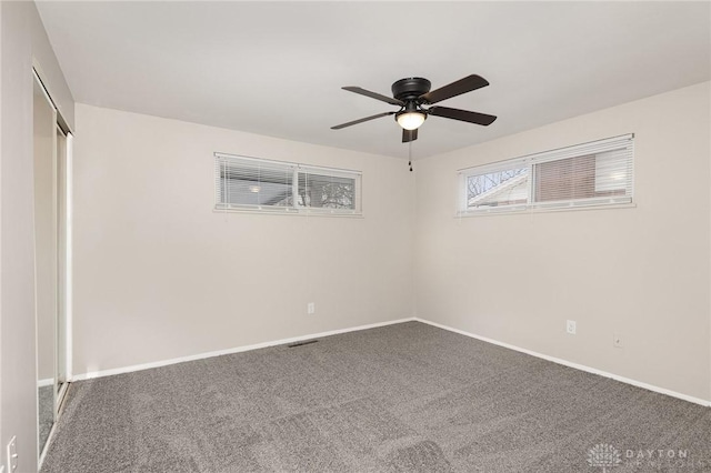 carpeted spare room featuring ceiling fan