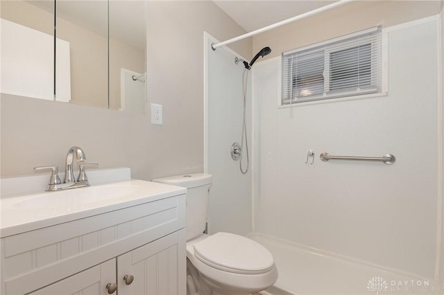 bathroom with walk in shower, vanity, and toilet