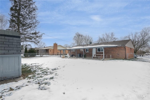 view of snow covered rear of property