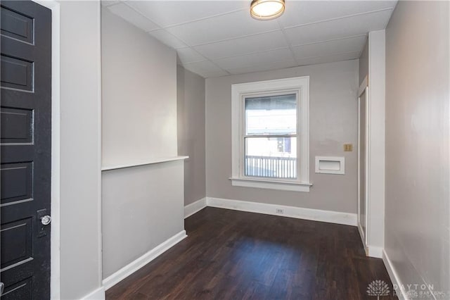 unfurnished room featuring a drop ceiling and dark hardwood / wood-style floors