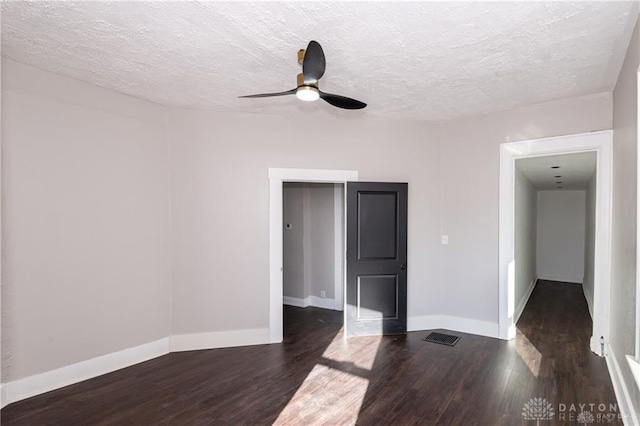 spare room with ceiling fan, dark hardwood / wood-style floors, and a textured ceiling