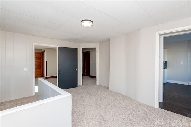 carpeted spare room featuring a paneled ceiling