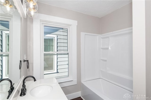 bathroom featuring vanity, tub / shower combination, and a textured ceiling