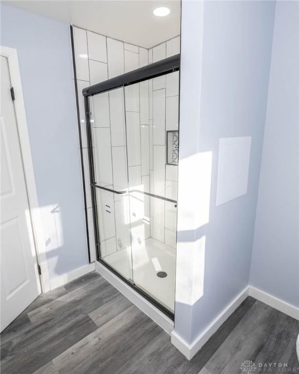 bathroom featuring hardwood / wood-style flooring and a shower with door