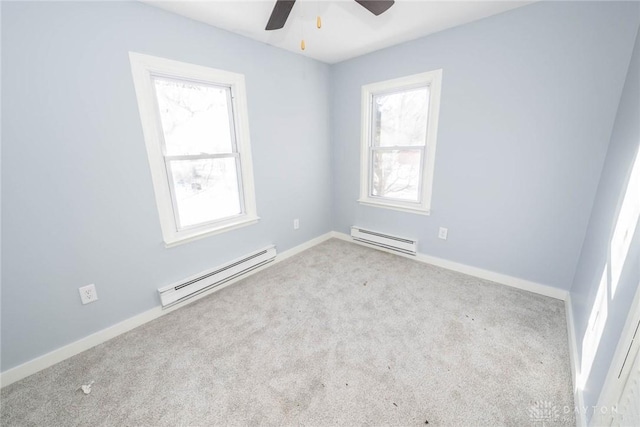 carpeted spare room with a baseboard radiator and ceiling fan