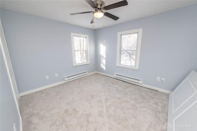 carpeted empty room featuring ceiling fan and baseboard heating