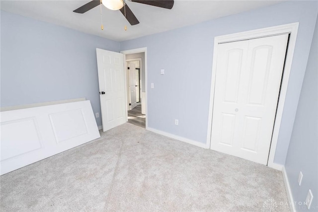 unfurnished bedroom featuring light carpet, a closet, and ceiling fan