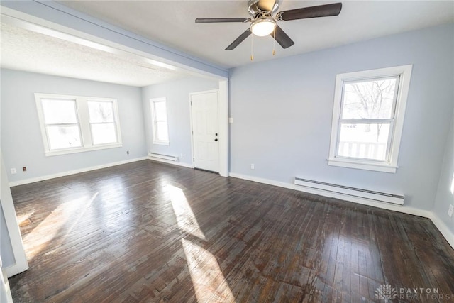 spare room featuring ceiling fan, dark wood-type flooring, and baseboard heating