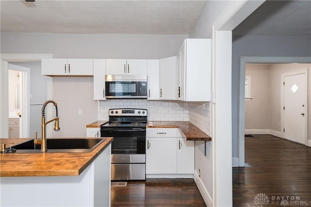 kitchen featuring sink, tasteful backsplash, wooden counters, stainless steel appliances, and white cabinets