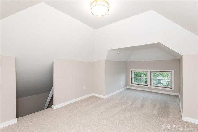 bonus room featuring light colored carpet and vaulted ceiling