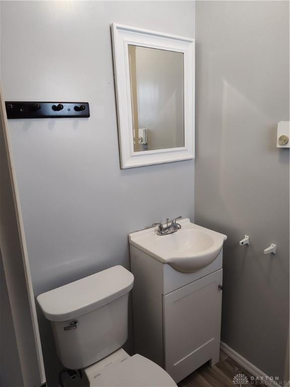 bathroom featuring vanity, toilet, and baseboards