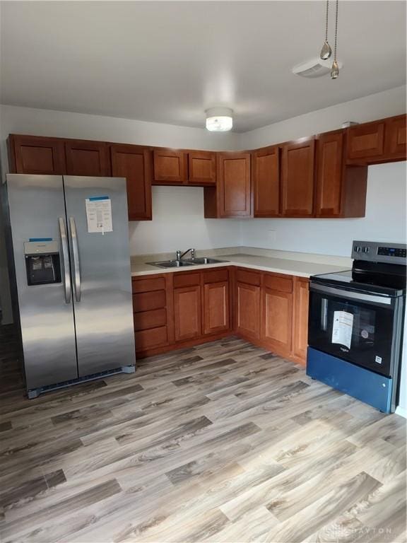 kitchen with light countertops, appliances with stainless steel finishes, and light wood-style floors