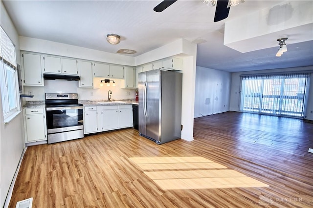 kitchen with stainless steel appliances, sink, ceiling fan, and light hardwood / wood-style flooring