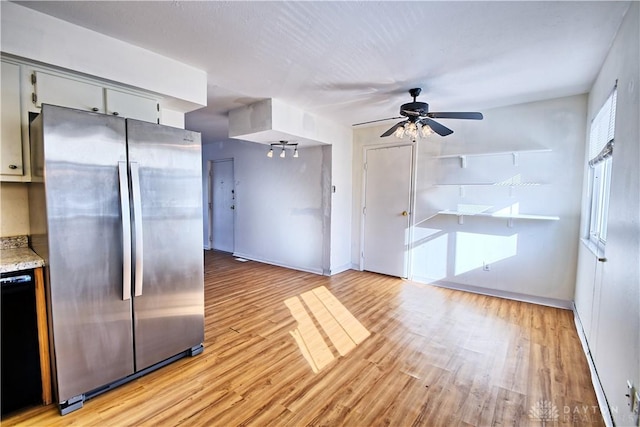 kitchen featuring black dishwasher, stainless steel fridge, ceiling fan, and light hardwood / wood-style flooring