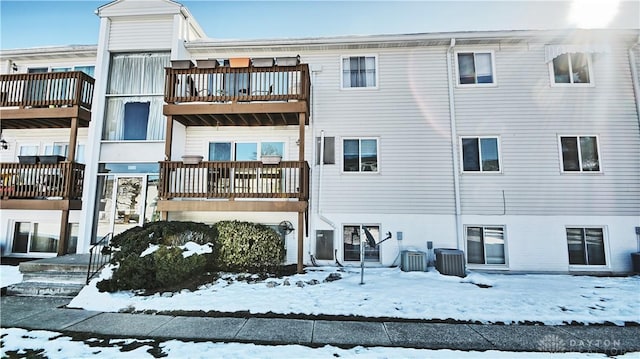 snow covered property with central AC unit