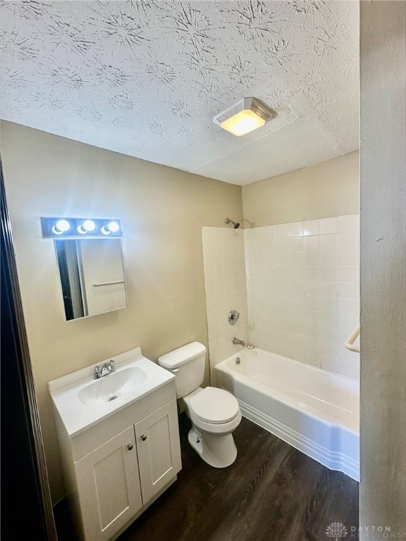 full bathroom with shower / bathing tub combination, wood-type flooring, vanity, toilet, and a textured ceiling