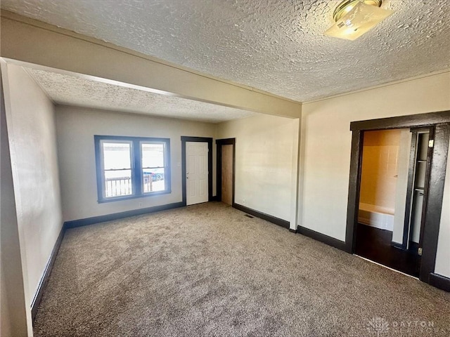 spare room featuring carpet and a textured ceiling