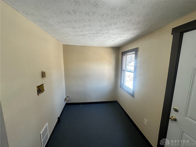 unfurnished room featuring a textured ceiling