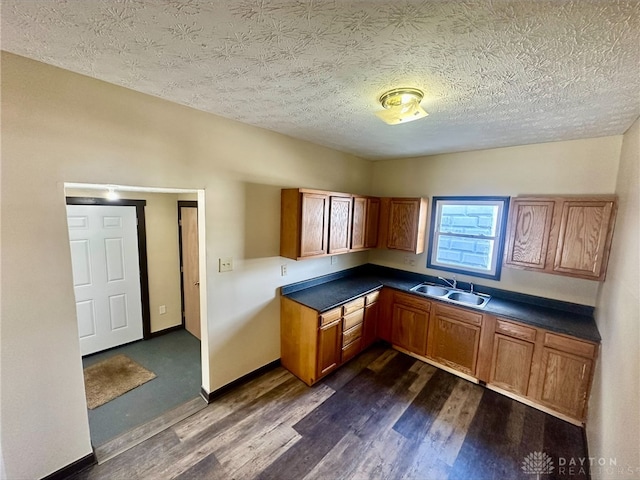 kitchen featuring dark hardwood / wood-style floors, sink, and a textured ceiling