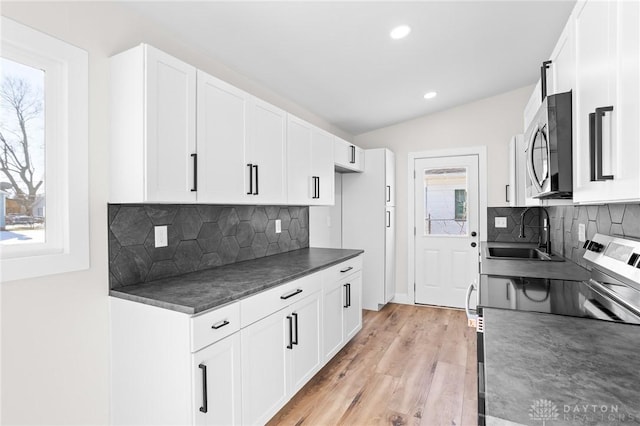 kitchen featuring tasteful backsplash, sink, white cabinets, and light hardwood / wood-style flooring