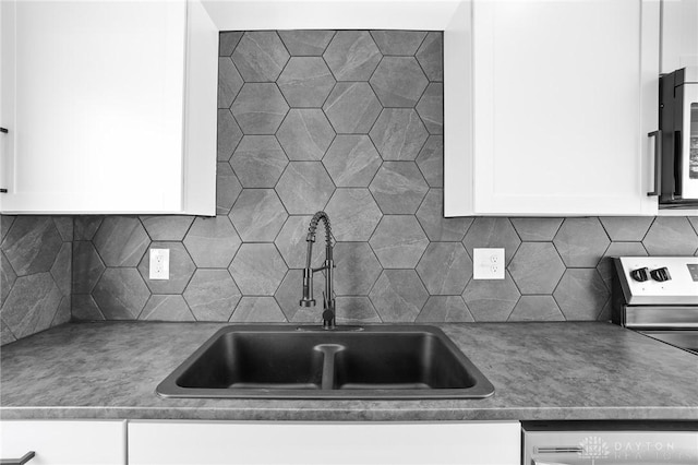 kitchen featuring white cabinetry, stainless steel appliances, sink, and backsplash