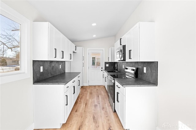 kitchen featuring lofted ceiling, sink, light hardwood / wood-style flooring, stainless steel appliances, and white cabinets