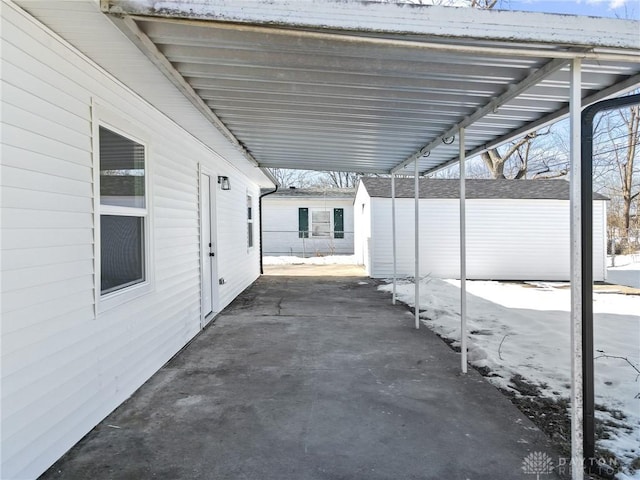 snow covered patio with a carport