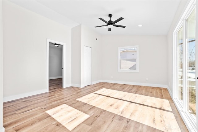 unfurnished bedroom featuring ceiling fan, vaulted ceiling, multiple windows, and light wood-type flooring