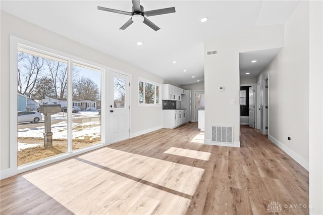 unfurnished living room with ceiling fan, lofted ceiling, and light hardwood / wood-style flooring