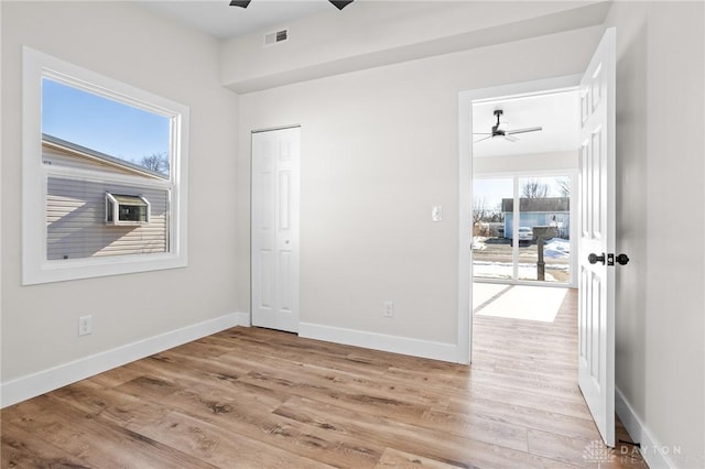 unfurnished bedroom with a closet, ceiling fan, and light wood-type flooring