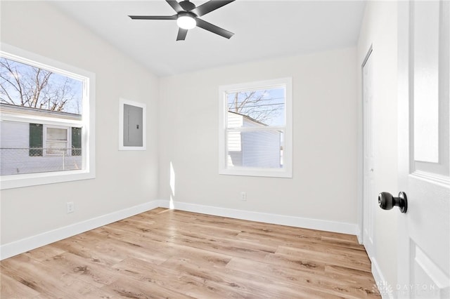 unfurnished room with ceiling fan, electric panel, and light wood-type flooring