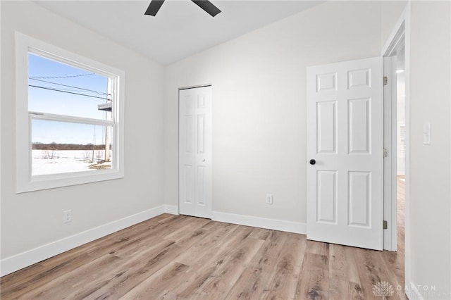 unfurnished bedroom featuring ceiling fan, light hardwood / wood-style floors, and a closet