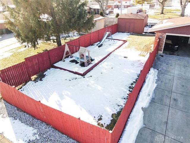 yard layered in snow with a garage and a storage shed