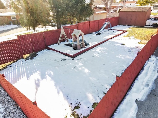 yard covered in snow with a storage shed