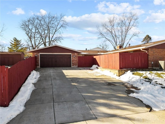 view of snow covered exterior with a garage and an outbuilding