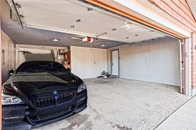 garage featuring a garage door opener and wood walls