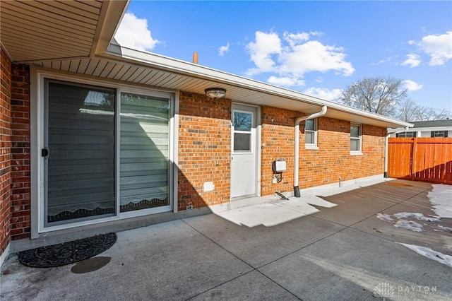 view of exterior entry with a patio area