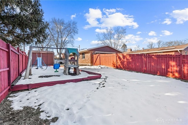 yard covered in snow with a playground