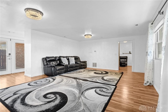 living room with french doors and light wood-type flooring