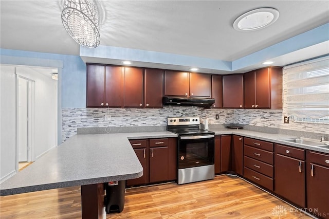 kitchen featuring tasteful backsplash, decorative light fixtures, stainless steel range with electric cooktop, and kitchen peninsula