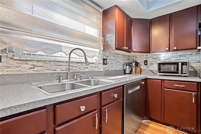 kitchen with appliances with stainless steel finishes, sink, and decorative backsplash