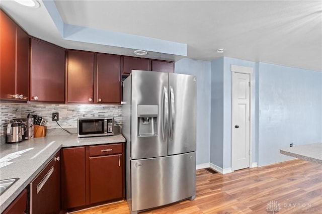 kitchen featuring decorative backsplash, light hardwood / wood-style flooring, and stainless steel appliances