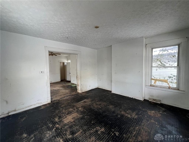 unfurnished room with a textured ceiling