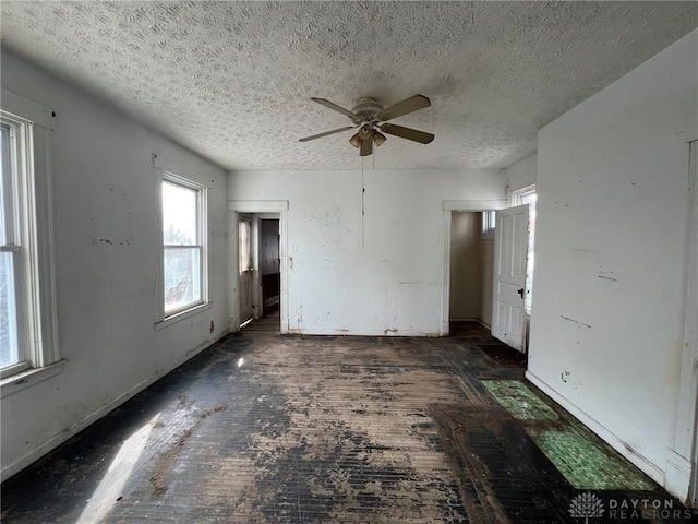 unfurnished room featuring ceiling fan and a textured ceiling