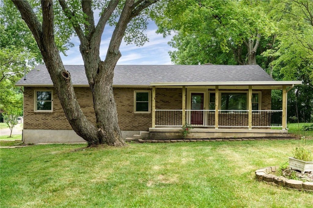 ranch-style home featuring a front yard and covered porch