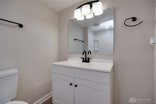 bathroom featuring vanity, toilet, and baseboards