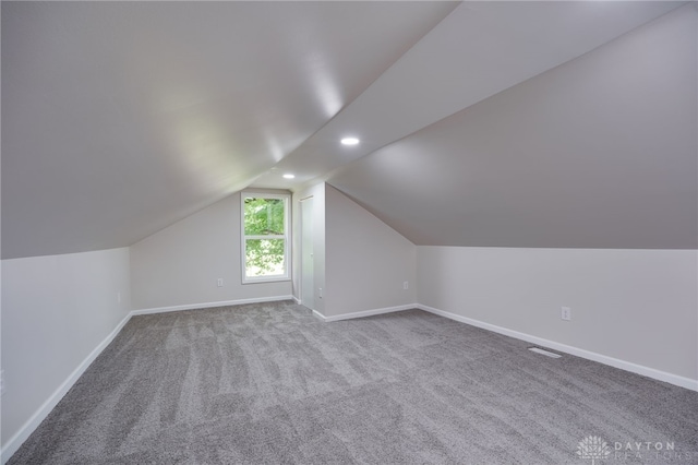 additional living space with lofted ceiling, carpet, baseboards, and visible vents