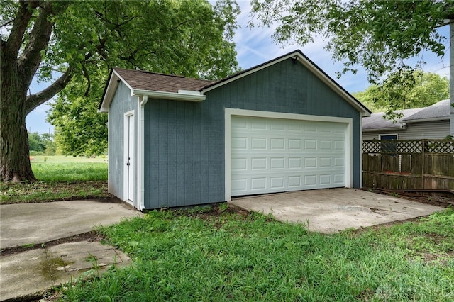 detached garage featuring fence